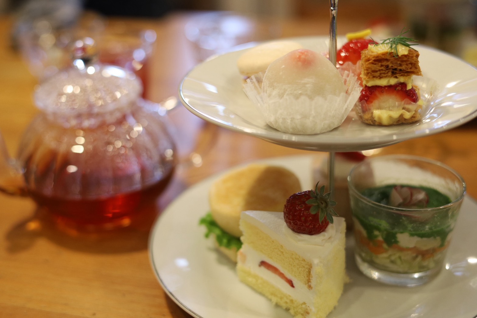 2段のアフタヌーンティースタンドといちごのショートケーキ、ハーブサラダのグラス、紅茶ポット
